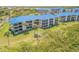 Stunning aerial view showcasing the condo complex's blue roofs and lush green surroundings at 2700 N Peninsula Ave # 513, New Smyrna Beach, FL 32169