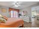 Bright bedroom featuring an orange quilt, ceiling fan, and door to a sitting room at 2700 N Peninsula Ave # 513, New Smyrna Beach, FL 32169