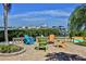 A waterfront patio with Adirondack chairs around a fire pit overlooks a dock and boats at 2700 N Peninsula Ave # 513, New Smyrna Beach, FL 32169