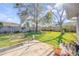 Backyard featuring lush green grass, mature trees, and a decorative garden at 2828 Pine Tree Dr, Edgewater, FL 32141