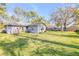 Spacious backyard featuring green grass, mature trees, and a glimpse of the home's exterior at 2828 Pine Tree Dr, Edgewater, FL 32141