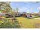 Beautiful home with lush green lawn and mature landscaping at 2828 Pine Tree Dr, Edgewater, FL 32141