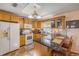 Open-concept kitchen featuring wood cabinets, granite countertops, and access to the dining area at 2828 Pine Tree Dr, Edgewater, FL 32141