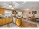 Open kitchen with wood cabinetry, granite counters, and access to the dining area at 2828 Pine Tree Dr, Edgewater, FL 32141