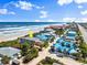 Aerial view showcasing a charming beach house with palm trees and ocean views at 2901 Hill St, New Smyrna Beach, FL 32169