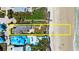 Aerial view of a beachfront home with a private patio, surrounded by lush landscaping and beach access at 2901 Hill St, New Smyrna Beach, FL 32169