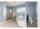 Blue bathroom features a soaking tub, walk-in shower, and tile flooring at 2901 Hill St, New Smyrna Beach, FL 32169