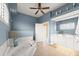 Bright blue primary bathroom featuring a luxurious soaking tub, double vanity and natural light at 2901 Hill St, New Smyrna Beach, FL 32169