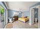 Well-lit bedroom with a ceiling fan, light blue walls and tile floors, flowing to a patio at 2901 Hill St, New Smyrna Beach, FL 32169