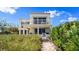 Gorgeous home exterior with a balcony, pathway, lush greenery and ocean views at 2901 Hill St, New Smyrna Beach, FL 32169