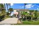 Inviting home with a well-kept lawn, mature palm trees, and a concrete driveway leading to the front entrance at 2901 Hill St, New Smyrna Beach, FL 32169