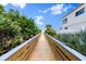 Picturesque wooden walkway through lush greenery leading to a beautiful beach and blue sky at 2901 Hill St, New Smyrna Beach, FL 32169