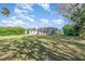 Large, green backyard featuring a screened-in pool area with mature trees and landscaping for privacy at 2908 Cypress Ridge Trl, Port Orange, FL 32128