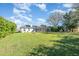 Spacious backyard with a screened pool enclosure, mature trees, and lush lawn, creating a serene outdoor space at 2908 Cypress Ridge Trl, Port Orange, FL 32128