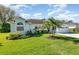 Beautifully landscaped front yard with lush green grass, palm trees, and manicured shrubbery enhancing curb appeal at 2908 Cypress Ridge Trl, Port Orange, FL 32128