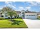 Inviting single-story home featuring a well-manicured lawn, mature landscaping, and a two-car garage at 2908 Cypress Ridge Trl, Port Orange, FL 32128