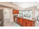 Well-equipped kitchen featuring wooden cabinetry, tile floors, and granite countertops at 2908 Cypress Ridge Trl, Port Orange, FL 32128