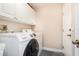 Well-lit laundry room featuring a modern Samsung washer and dryer set with convenient white cabinets above at 2908 Cypress Ridge Trl, Port Orange, FL 32128