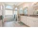 Bright bathroom features double sinks, a glass-enclosed shower, and a soaking tub under a decorative window at 2908 Cypress Ridge Trl, Port Orange, FL 32128