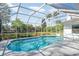 Sparkling in-ground pool inside a screened enclosure, surrounded by well-maintained landscaping and an open backyard at 2908 Cypress Ridge Trl, Port Orange, FL 32128
