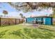 A lush backyard featuring manicured lawn, patio, dining table, and grill setup for outdoor gatherings at 301 N Cooper St, New Smyrna Beach, FL 32169