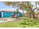 Outdoor dining with a large backyard, featuring mature trees, grill, and privacy fencing at 301 N Cooper St, New Smyrna Beach, FL 32169