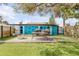 Inviting backyard features an outdoor kitchen, dining, privacy fence and mature trees at 301 N Cooper St, New Smyrna Beach, FL 32169