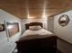 Warm and inviting bedroom with a wood-paneled ceiling and a cozy king-sized bed at 301 N Cooper St, New Smyrna Beach, FL 32169