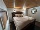 Warm and inviting bedroom with a wood-paneled ceiling and a cozy king-sized bed at 301 N Cooper St, New Smyrna Beach, FL 32169