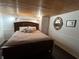 Warm and inviting bedroom with a wood-paneled ceiling and a cozy king-sized bed at 301 N Cooper St, New Smyrna Beach, FL 32169