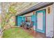 Cozy outdoor patio space with chairs, lush green grass and vibrant turquoise shutters at 301 N Cooper St, New Smyrna Beach, FL 32169