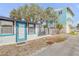 Side exterior view showing blue-trimmed details and gravel landscaping at 301 N Cooper St, New Smyrna Beach, FL 32169