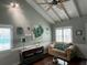 Comfortable living room with vaulted ceilings, large windows, and stylish decor at 301 N Cooper St, New Smyrna Beach, FL 32169