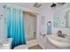 Bathroom with blue ombre shower curtain, white tub, toilet, and mirrored vanity at 303 Washington St, New Smyrna Beach, FL 32168