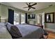 Bedroom with hardwood floors, large windows, ceiling fan, and a modern TV at 303 Washington St, New Smyrna Beach, FL 32168