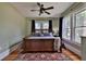 Comfortable bedroom with hardwood floors, a ceiling fan, large windows, and a cozy rug at 303 Washington St, New Smyrna Beach, FL 32168