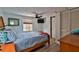 Cozy bedroom with a wooden bed frame, ceiling fan, and closet with louvered doors at 303 Washington St, New Smyrna Beach, FL 32168