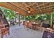 Outdoor deck with a wooden dining table, grill, and a shaded seating area at 303 Washington St, New Smyrna Beach, FL 32168