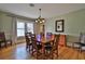 Charming dining room with hardwood floors, a craftsman style chandelier, and a wooden table with seating for six at 303 Washington St, New Smyrna Beach, FL 32168