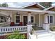 Charming front porch featuring red chairs, ceiling fans, and stylish columns, perfect for relaxing at 303 Washington St, New Smyrna Beach, FL 32168