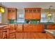 Well-lit kitchen featuring custom cabinets, a tiled backsplash, stainless steel appliances, and hardwood floors at 303 Washington St, New Smyrna Beach, FL 32168