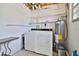 Functional laundry room with a washer, dryer, water heater, and storage shelves at 303 Washington St, New Smyrna Beach, FL 32168