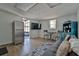 Open-concept living area featuring a refrigerator, TV, sofa, coffee bar, and wood-look flooring at 303 Washington St, New Smyrna Beach, FL 32168