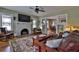 Comfortable living room featuring a brick fireplace, hardwood floors, and ceiling fan at 303 Washington St, New Smyrna Beach, FL 32168
