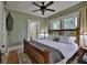 Cozy main bedroom with hardwood floors, ceiling fan and large windows for natural light at 303 Washington St, New Smyrna Beach, FL 32168