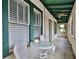 Charming porch with green trim provides additional outdoor seating and lounging space at 303 Washington St, New Smyrna Beach, FL 32168
