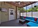 Relaxing screened porch with a comfortable blue sofa, coffee table, and outdoor access at 303 Washington St, New Smyrna Beach, FL 32168