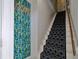 Bright stairwell with patterned carpet and unique wallpaper with a coat rack at 303 Washington St, New Smyrna Beach, FL 32168