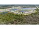 An aerial view displays a community featuring water views near lush wooded areas and convenient highway access at 3245 Carpentaria Dr, New Smyrna Beach, FL 32168