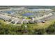 An aerial view showcasing a residential community near a serene lake, bordered by lush green trees at 3245 Carpentaria Dr, New Smyrna Beach, FL 32168